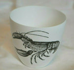 A white porcelain votive candle vase featuring a black and white lobster design from the brand Two's Company.